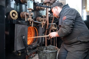 A fireman lighting up the fire in a steam locomotive.