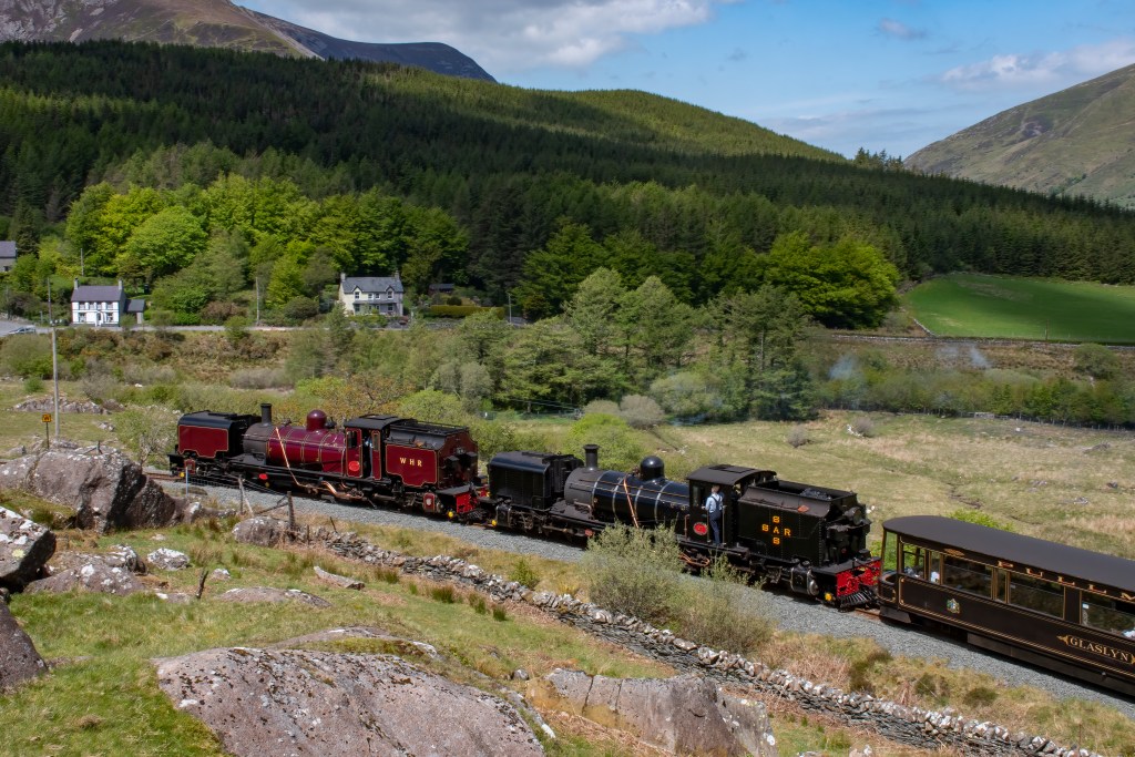 Steam train with two NGG16 Garratts at the front, with the picturesque backdrop of the Cwellyn valley.